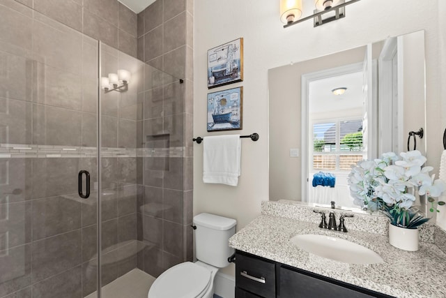 full bathroom with vanity, toilet, and a shower stall