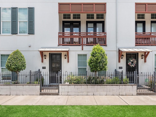 view of front of home featuring fence, a gate, and stucco siding