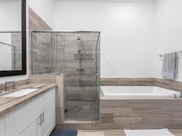 bathroom featuring vanity, a shower stall, and a bath
