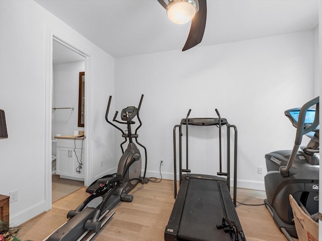 exercise room with baseboards and wood finished floors