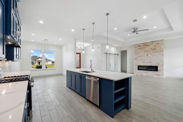 kitchen featuring a ceiling fan, blue cabinetry, a sink, stainless steel appliances, and extractor fan