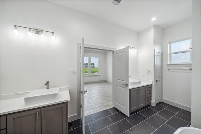 full bathroom with a sink, tile patterned floors, baseboards, two vanities, and visible vents