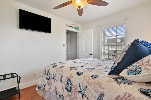 bedroom featuring baseboards, ceiling fan, and wood finished floors