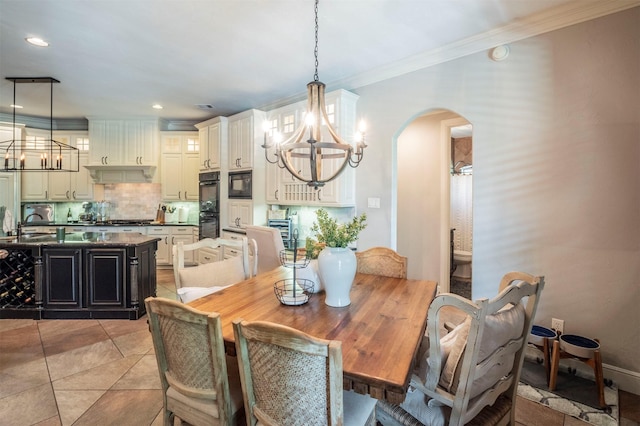 dining area with an inviting chandelier, arched walkways, crown molding, and recessed lighting