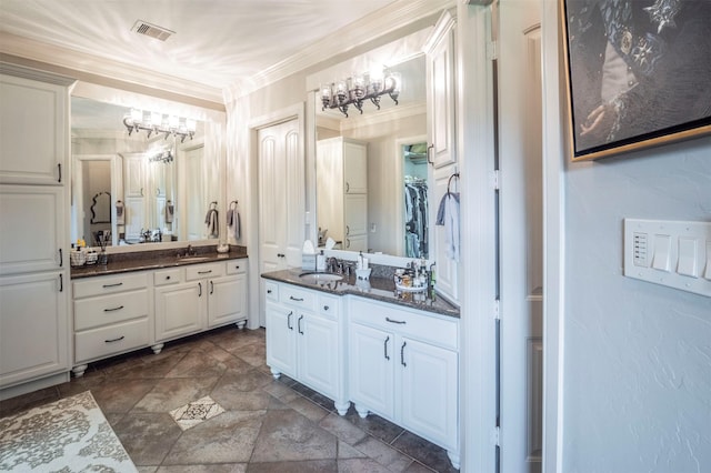 bathroom with visible vents, a sink, two vanities, and a notable chandelier