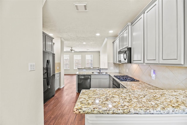 7824 Stoneyway Dr, Houston, TX 77040 - kitchen featuring visible vents, dark wood-style flooring, a peninsula, a sink, and black appliances