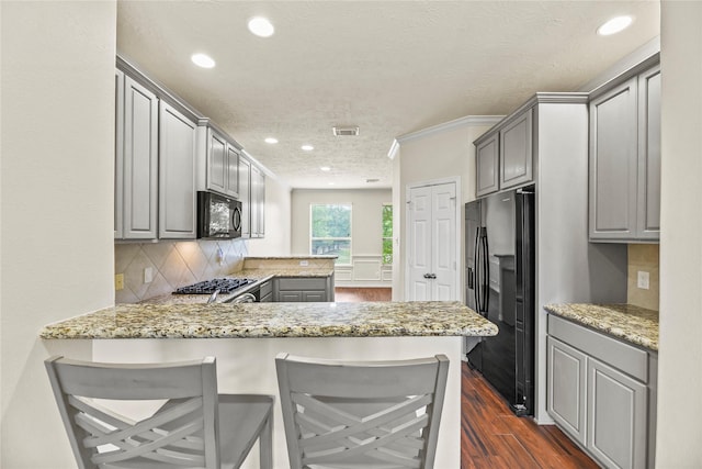 7824 Stoneyway Dr, Houston, TX 77040 - kitchen with visible vents, dark wood-style flooring, black appliances, and gray cabinetry