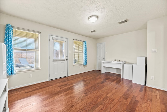 7824 Stoneyway Dr, Houston, TX 77040 - entryway featuring a textured ceiling, baseboards, wood finished floors, and visible vents