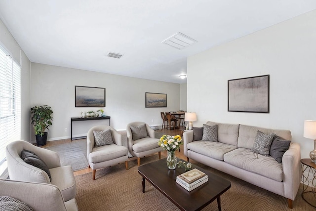living area featuring baseboards, wood finished floors, and visible vents