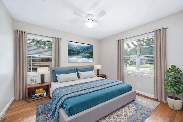 bedroom with baseboards, ceiling fan, and light wood-type flooring