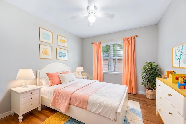 bedroom featuring a ceiling fan, baseboards, and light wood-type flooring