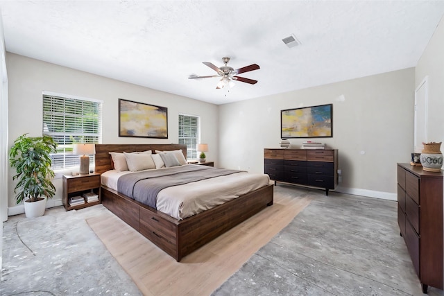 bedroom featuring baseboards, a ceiling fan, concrete floors, and visible vents