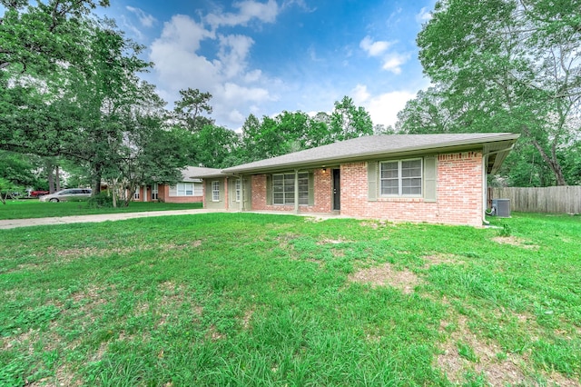 single story home featuring brick siding, central AC unit, a front lawn, and fence