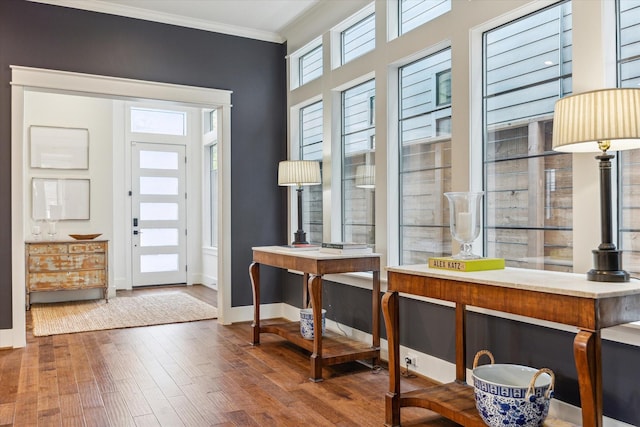entryway with baseboards, ornamental molding, and hardwood / wood-style floors