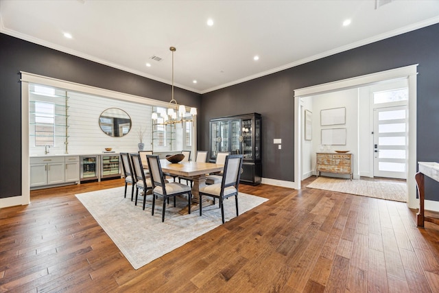 dining area with an inviting chandelier, wood-type flooring, recessed lighting, wine cooler, and visible vents