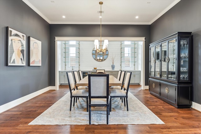 dining room featuring crown molding, wood finished floors, and a notable chandelier