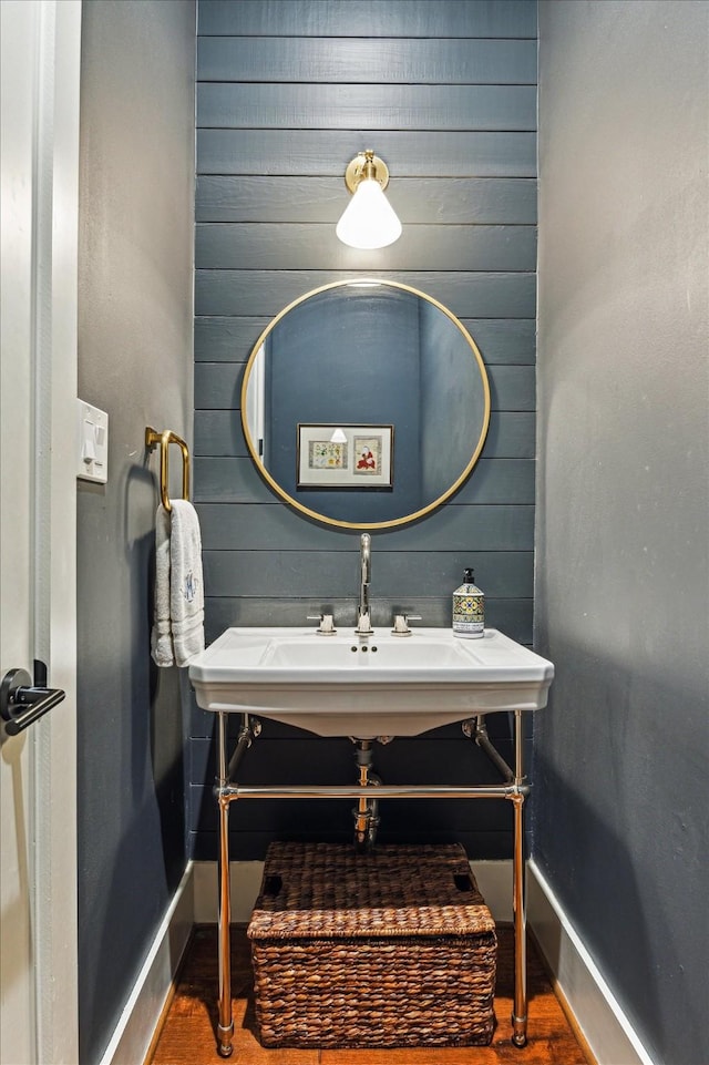 bathroom with baseboards and wood walls