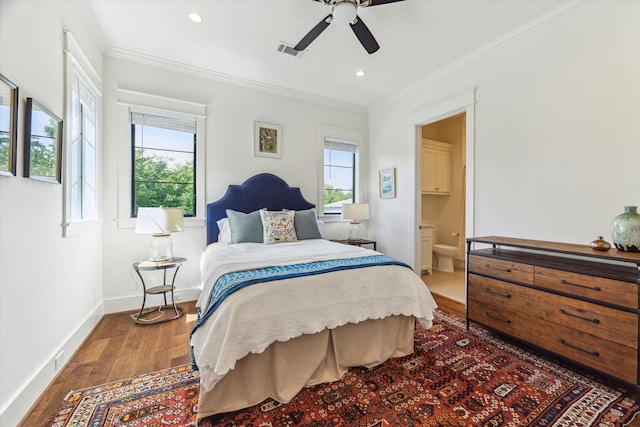 bedroom featuring visible vents, crown molding, wood finished floors, and multiple windows