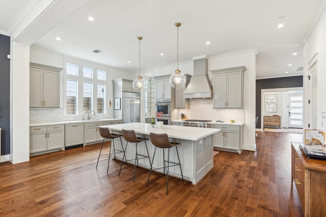 kitchen featuring gray cabinets, a kitchen island, dark wood-style flooring, custom range hood, and stainless steel appliances