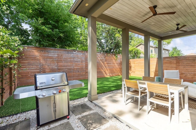 view of patio / terrace with a fenced backyard, a ceiling fan, area for grilling, and outdoor dining space