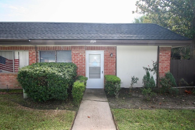 12024 Mighty Oak Dr Unit A, Houston, TX 77066 - view of exterior entry featuring a shingled roof and brick siding