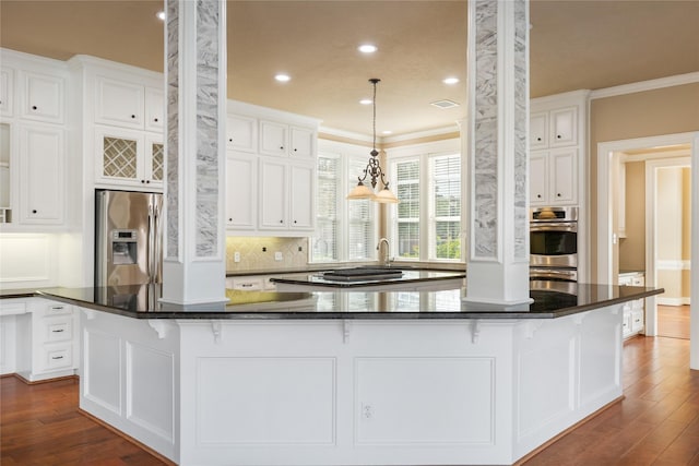 5811 Cimmaron Creek Ct, Spring, TX 77379 - kitchen featuring ornamental molding, a large island, dark wood-type flooring, white cabinetry, and appliances with stainless steel finishes