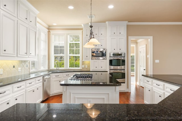 5811 Cimmaron Creek Ct, Spring, TX 77379 - kitchen featuring crown molding, wood finished floors, tasteful backsplash, a sink, and appliances with stainless steel finishes