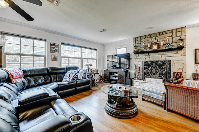 living room with visible vents, ornamental molding, and a wealth of natural light
