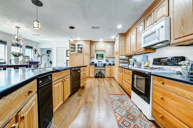 kitchen with dark countertops, a sink, electric stove, and white microwave