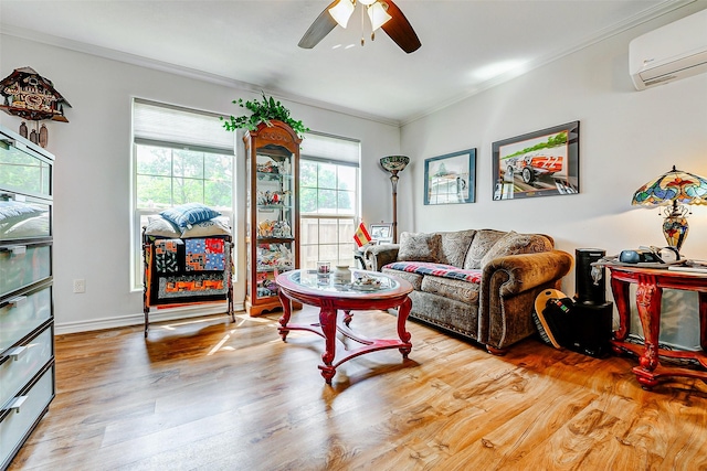 living room with ornamental molding, wood finished floors, baseboards, a wall mounted air conditioner, and a ceiling fan