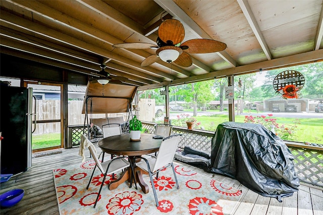 sunroom with ceiling fan, beamed ceiling, and outdoor dining area