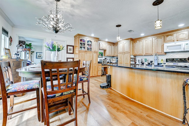 kitchen with electric range, dark countertops, light wood-style flooring, and white microwave