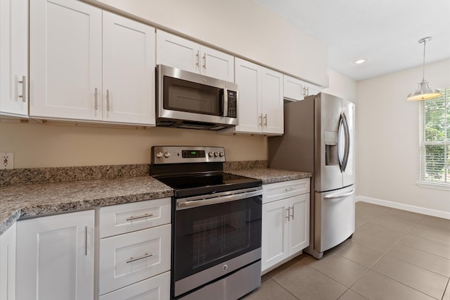 7545 Brompton St Unit 7545, Houston, TX 77025 - kitchen featuring stainless steel appliances, white cabinets, light tile patterned floors, baseboards, and recessed lighting