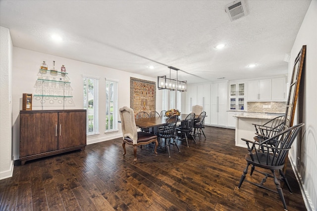dining space with recessed lighting, dark wood finished floors, a textured ceiling, and visible vents