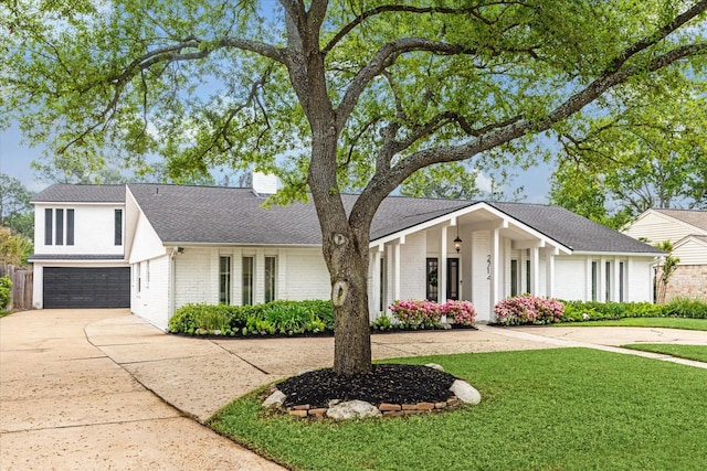 view of front of property with an attached garage, a chimney, concrete driveway, and brick siding