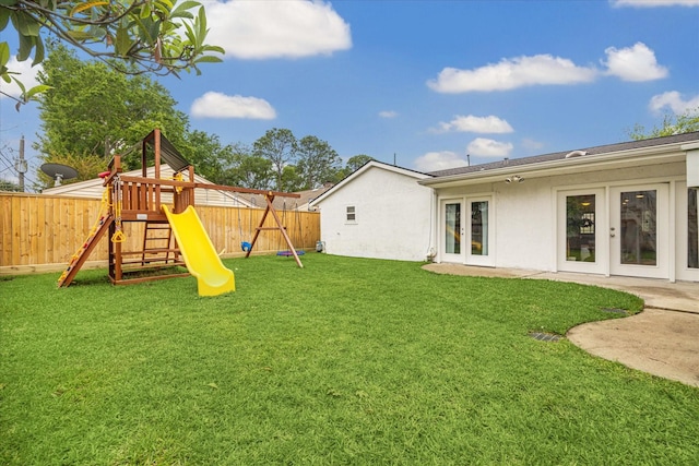 view of yard with french doors, a playground, and a fenced backyard