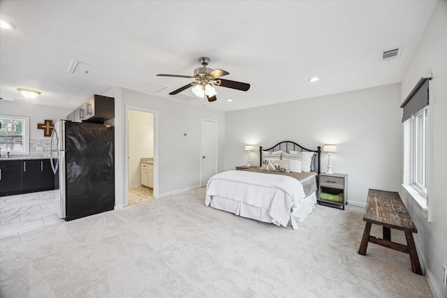 bedroom featuring ensuite bath, attic access, freestanding refrigerator, baseboards, and visible vents