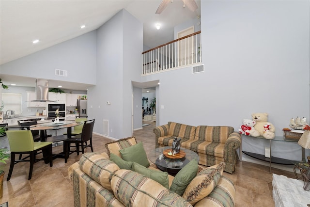 living area featuring a ceiling fan, high vaulted ceiling, and visible vents