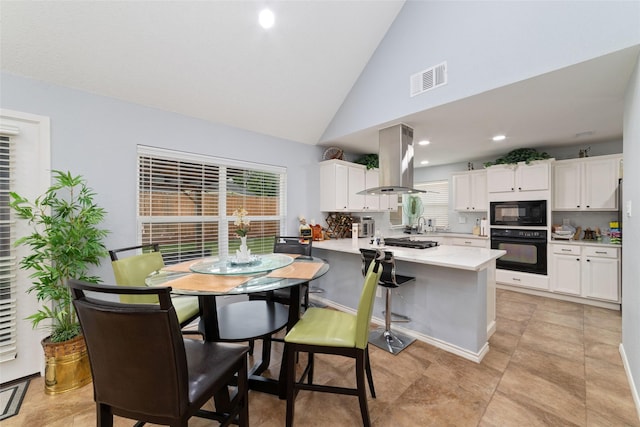 kitchen featuring white cabinets, visible vents, island range hood, and black appliances