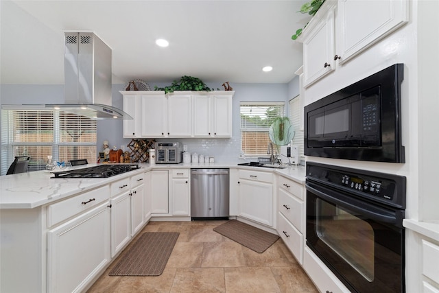 kitchen featuring decorative backsplash, island range hood, a sink, white cabinets, and black appliances