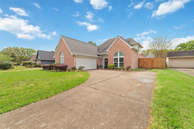 view of front of home featuring fence, an attached garage, a front lawn, brick siding, and driveway