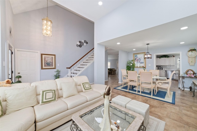living room featuring recessed lighting, high vaulted ceiling, and a chandelier