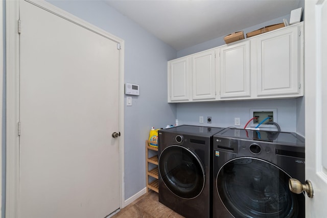 clothes washing area featuring baseboards, cabinet space, and washer and clothes dryer