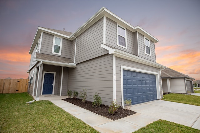 traditional home with a garage, fence, a lawn, and driveway
