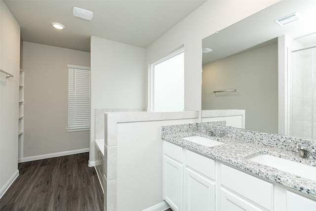 full bathroom featuring baseboards, visible vents, a sink, and wood finished floors