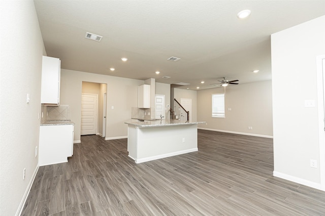 kitchen with baseboards, light wood-style floors, white cabinets, and visible vents