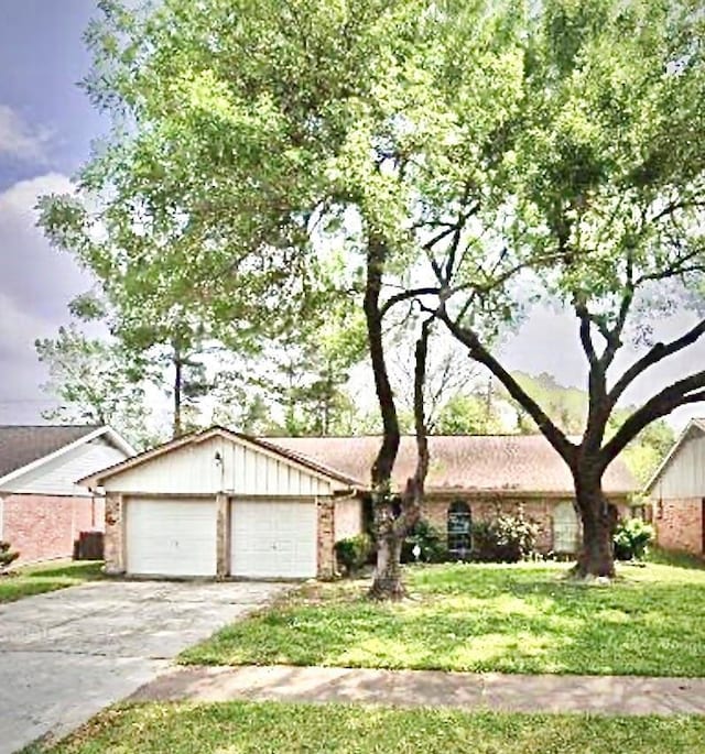 335 Haymarket Ln, Houston, TX 77015 - ranch-style home featuring board and batten siding, a garage, brick siding, a front lawn, and concrete driveway
