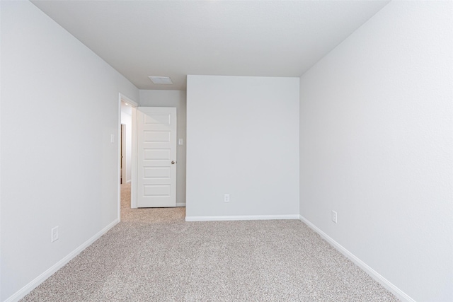 spare room featuring light colored carpet, baseboards, and visible vents