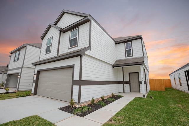 view of front of property with an attached garage, a front lawn, fence, and driveway