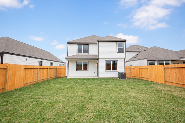 rear view of property featuring central AC unit, a fenced backyard, and a yard
